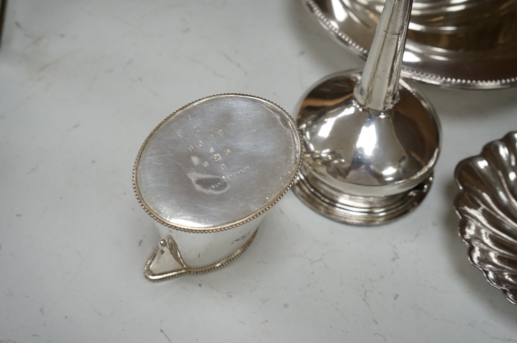 A Mappin plated muffin dish and six other plated items including three Old Sheffield plate butter shells, a wine funnel, Elkington & Co cream jug and cased set of tea knives.